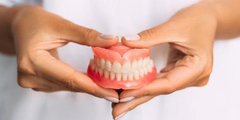 Lady presents viewer with dentures