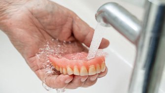 Denture being rinsed