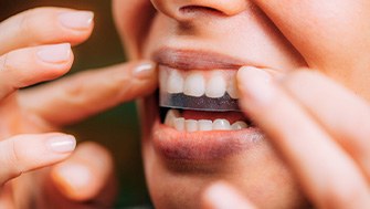 Patient putting whitening strip on
