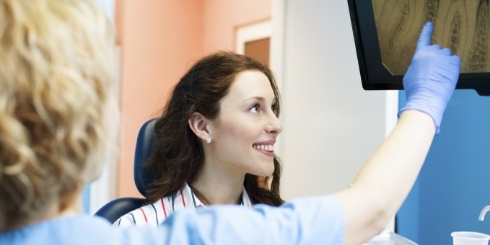 Dentist and dental patient looking at digital x-rays