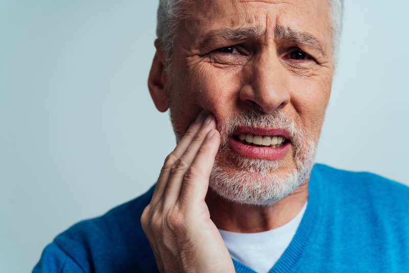 Patient with dentures rubbing their cheek