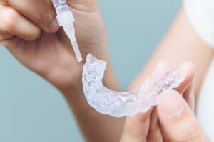 Person using an at-home teeth whitening kit